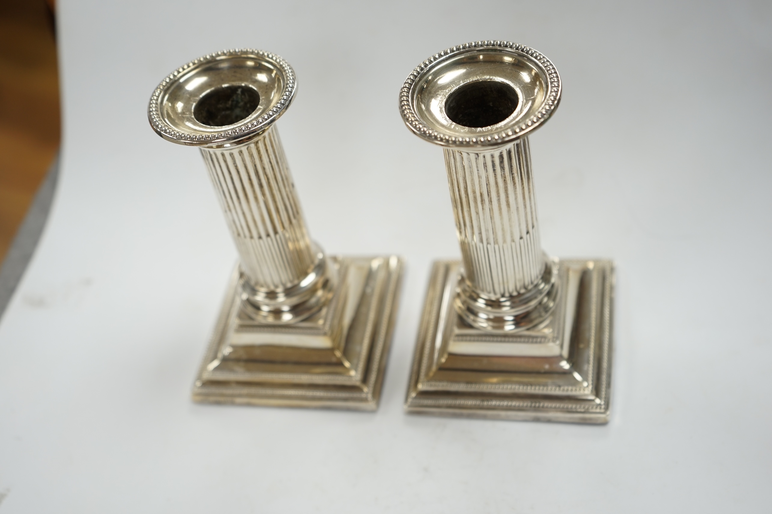 A pair of Edwardian silver dwarf candlesticks, Thomas A. Scott, Sheffield, 1905, height 12.5cm, weighted. Condition - fair